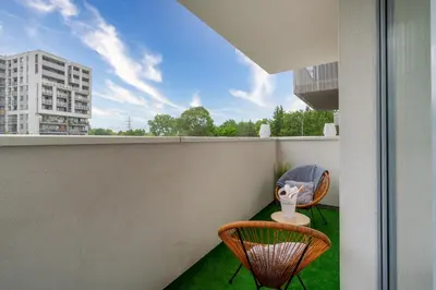 a balcony with two chairs and a table at Exclusive Crystal Apartment in Kraków