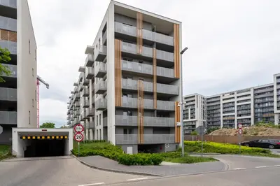 an apartment building with a parking garage in front of it at Exclusive Crystal Apartment in Kraków