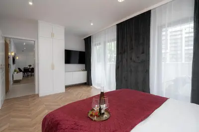 a bedroom with a bed with two wine glasses on it at Exclusive Crystal Apartment in Kraków
