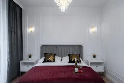 a bedroom with a large bed with a wine bottle on it at Exclusive Crystal Apartment in Kraków