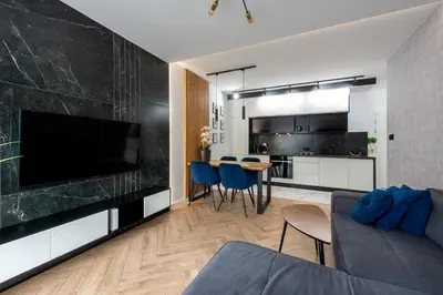 a living room with a couch and a tv and a kitchen at City of the Kings - Podskale 18 in Kraków