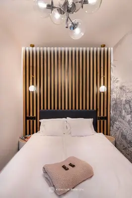 a bedroom with a white bed with a striped wall at City of the Kings - Podskale 18 in Kraków