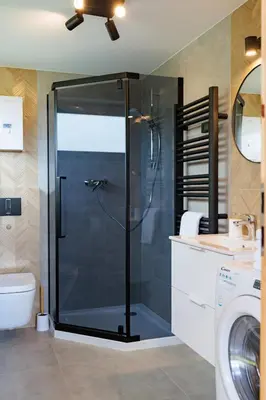 a shower with a glass door in a bathroom at Stodoły Modyń - Domki w Beskidzie Wyspowym - staw kąpielowy, balia, sauna, grota solna - widok na góry in Kamienica