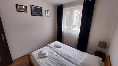 a small bedroom with a bed and a window at Apartament przy Łąkach - Zakodomki (Kraków) in Kraków