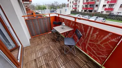 a balcony with a table and chairs on a building at Apartament przy Łąkach - Zakodomki (Kraków) in Kraków