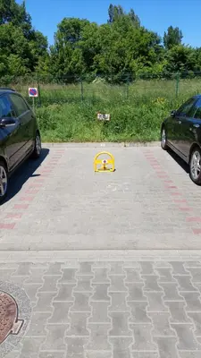 a yellow object in a parking lot with two cars at Apartament przy Łąkach - Zakodomki (Kraków) in Kraków