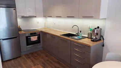 a kitchen with a sink and a refrigerator at Apartament przy Łąkach - Zakodomki (Kraków) in Kraków