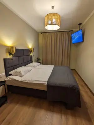 a bedroom with a large bed and a television at Spacious Two-Bedroom Apartment in the City Center in Kraków