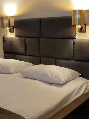 a bed with a black headboard and a white pillow at Spacious Two-Bedroom Apartment in the City Center in Kraków