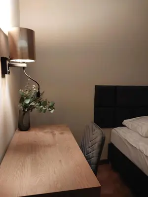 a room with a table and a bed and a lamp at Spacious Two-Bedroom Apartment in the City Center in Kraków