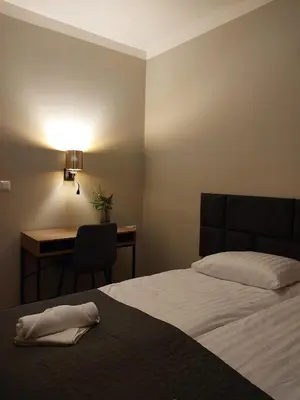 a bedroom with a bed and a desk with a lamp at Spacious Two-Bedroom Apartment in the City Center in Kraków