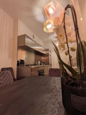 a dining room table with a vase of flowers on it at Spacious Two-Bedroom Apartment in the City Center in Kraków