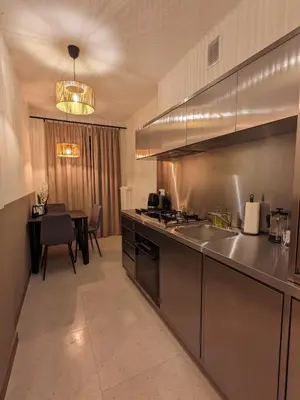 a large kitchen with a sink and a table at Spacious Two-Bedroom Apartment in the City Center in Kraków