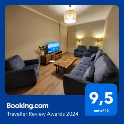 a living room with a couch and a tv at Spacious Two-Bedroom Apartment in the City Center in Kraków