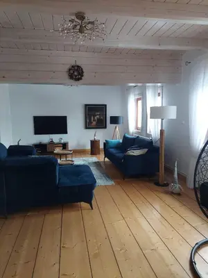 a living room with blue couches and a wooden floor at Villa Marlena - basen, balia, grill, billard, ogród i relaks in Spytkowice
