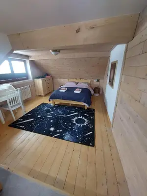 a bedroom with a bed on a wooden floor at Villa Marlena - basen, balia, grill, billard, ogród i relaks in Spytkowice