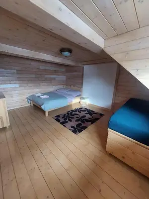 a room with two beds in a log cabin at Villa Marlena - basen, balia, grill, billard, ogród i relaks in Spytkowice