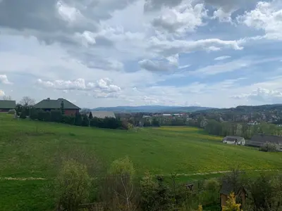 a green field with a house in the distance at Villa Marlena - basen, balia, grill, billard, ogród i relaks in Spytkowice