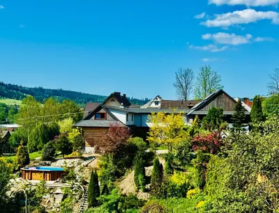 a group of houses on a hill with trees at Villa Marlena - basen, balia, grill, billard, ogród i relaks in Spytkowice