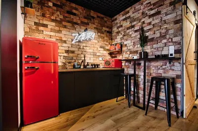 a red refrigerator in a kitchen with a brick wall at Zadzior4 by Housine in Zator