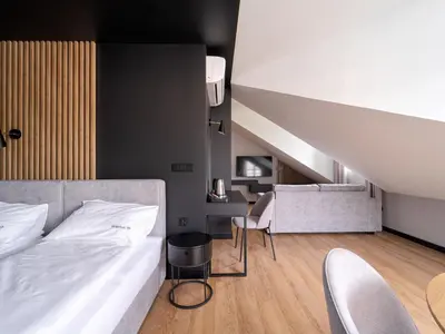 a bedroom with a bed and a desk and chairs at Stek Apartments ApartHotel in Skawina