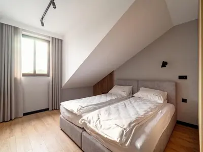 a bedroom with a bed with white sheets and a window at Stek Apartments ApartHotel in Skawina