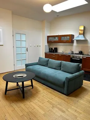 a living room with a blue couch and a table at GOLDEN APARTMENTS with Lift - OLD TOWN in Kraków