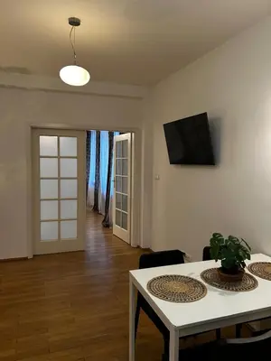 a living room with a table and a tv on the wall at GOLDEN APARTMENTS with Lift - OLD TOWN in Kraków