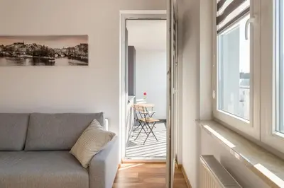 a living room with a couch and a window at Zabłocie Beauty Stay in Kraków