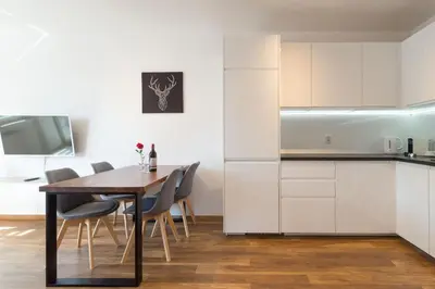 a kitchen and dining room with a table and chairs at Zabłocie Beauty Stay in Kraków