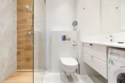 a white bathroom with a toilet and a sink at Zabłocie Beauty Stay in Kraków