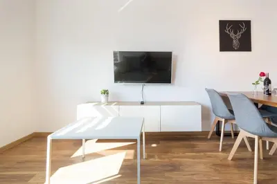 a dining room with a white table and chairs at Zabłocie Beauty Stay in Kraków
