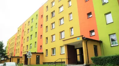 a multicolored building with a car parked in front of it at Apartament ENJOY Zator - z widokiem na Energylandie in Zator