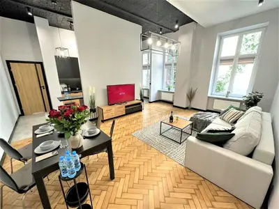 a living room with a couch and a table at LUXURY 100m2 LOFT Design-Apartment at WAWEL + Netflix in Kraków