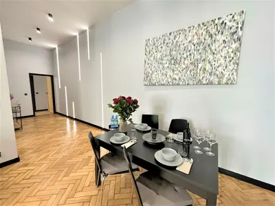 a dining room with a table and a painting on the wall at LUXURY 100m2 LOFT Design-Apartment at WAWEL + Netflix in Kraków