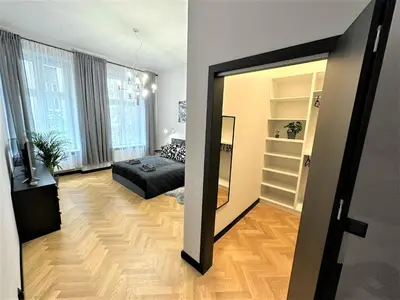 a bedroom with a bed and a mirror in a room at LUXURY 100m2 LOFT Design-Apartment at WAWEL + Netflix in Kraków