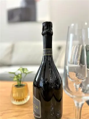 a bottle of wine sitting on a table with two glasses at LUXURY 100m2 LOFT Design-Apartment at WAWEL + Netflix in Kraków