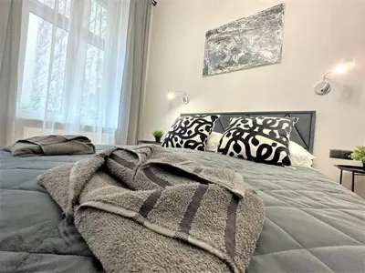 a bedroom with a bed with a blanket on it at LUXURY 100m2 LOFT Design-Apartment at WAWEL + Netflix in Kraków