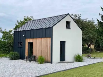 a black and white shed with a black roof at Zatorska 113 - Zachwycający domek gościnny in Podolsze