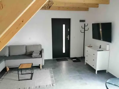a living room with a couch and a tv at Zatorska 113 - Zachwycający domek gościnny in Podolsze