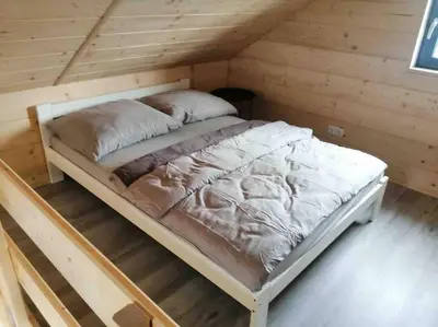 a bed in a room in a log cabin at Zatorska 113 - Zachwycający domek gościnny in Podolsze