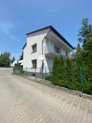 a white house with a fence in front of it at Energylandia Zator noclegi apartament pokoje do wynajęcia in Polanka Wielka