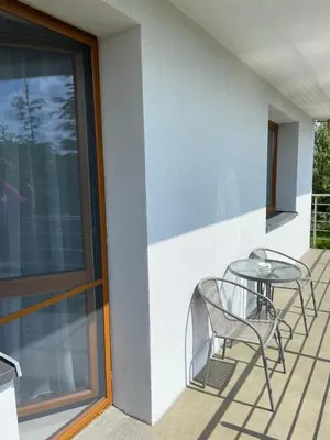 a patio with two chairs and a table on a balcony at Energylandia Zator noclegi apartament pokoje do wynajęcia in Polanka Wielka