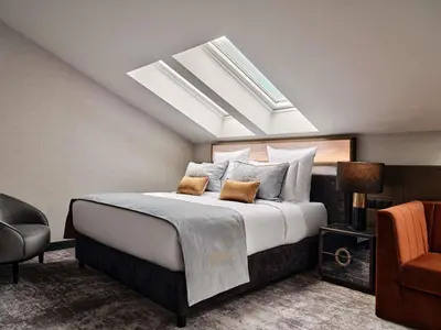 a bedroom with a large bed with a skylight at The Crown Krakow Center - Handwritten Collection ACCOR in Kraków