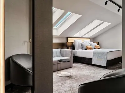 a hotel room with two beds and a television at The Crown Krakow Center - Handwritten Collection ACCOR in Kraków