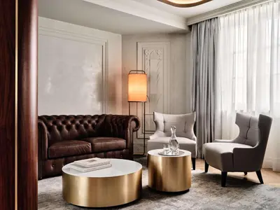 a living room with a couch and a table and a chair at The Crown Krakow Center - Handwritten Collection ACCOR in Kraków
