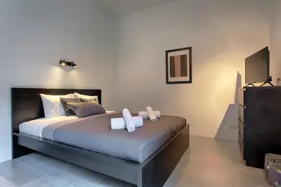 a bedroom with a bed with two towels on it at Tyzenhauz Apartments Wawel in Kraków