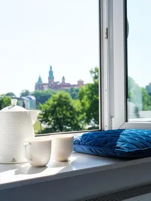 a window with three white cups on a window sill at Tyzenhauz Apartments Wawel in Kraków