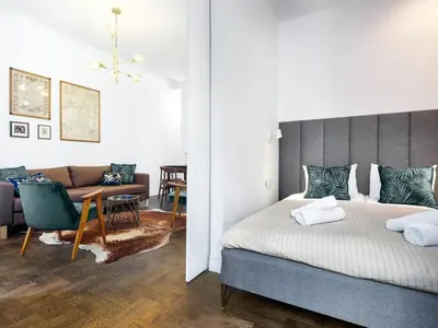 a bedroom with a bed and a living room at Tyzenhauz Apartments Wawel in Kraków