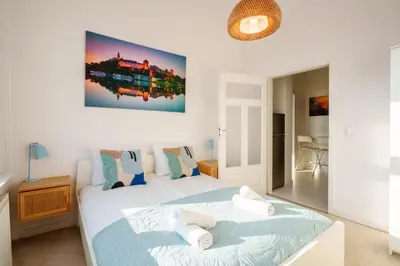 a bedroom with two beds and a painting on the wall at Tyzenhauz Apartments Wawel in Kraków